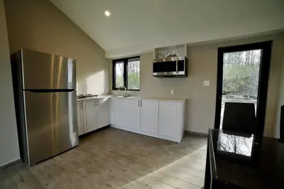 a kitchen with a stainless steel refrigerator and white cabinets at 1-bedroom Townhouse in Harwood #5 in Harwood
