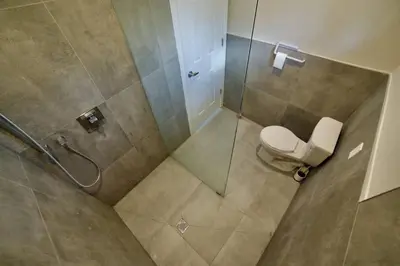 a bathroom with a toilet and a glass shower at 1-bedroom Townhouse in Harwood #5 in Harwood