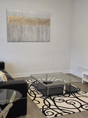 a living room with a glass coffee table and a painting at Modern 4 Bedroom Home -Oakville in Oakville