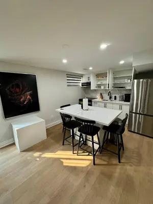a kitchen with a table and chairs and a refrigerator at 2 BR Private Basement Suite | Minutes from YYZ in Brampton