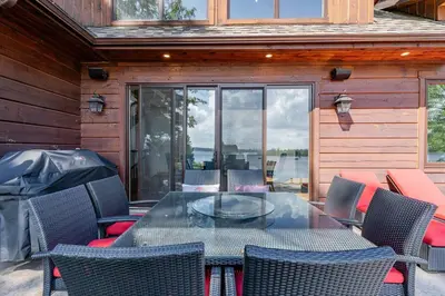 a patio with a glass table and chairs at Lakefront cottage with golf area BBQ pool table in Bobcaygeon