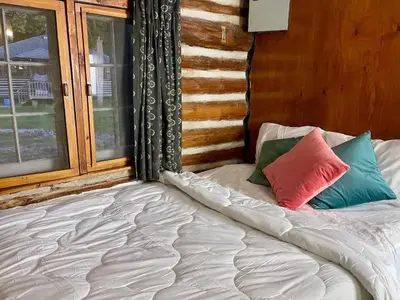 a bed with two pillows on it in front of a window at Balsam Lake - 2-Bedroom Cottage #8 in Kawartha Lakes