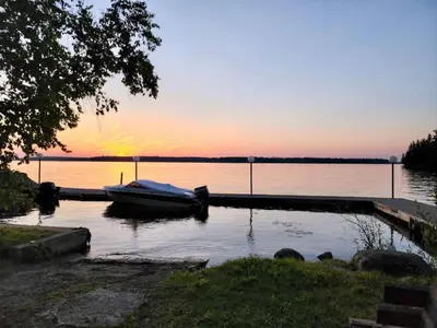 a boat is docked at a dock on a lake at 1-Bedroom Balsam Lake Cottage #9 in Kawartha Lakes