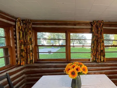 a vase of flowers on a table in a room with windows at Balsam Lake - 2-Bedroom Cottage #6 in Kawartha Lakes