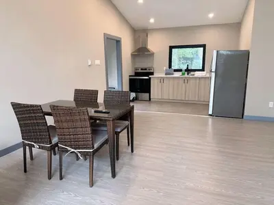a dining room with a table and chairs and a kitchen at 3-bedroom Lakefront Villa #7 in Lakefield