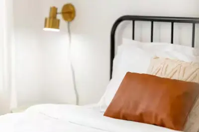 a white bed with a brown pillow on it at RentX Cozy Downtown London Parking WiFi in London