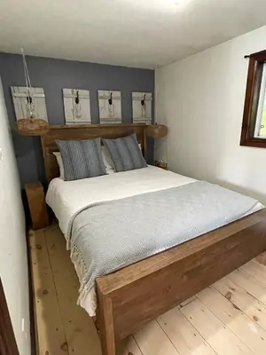 a bedroom with a wooden bed in a room at Muskoka Cabana - Sandy beach cottage in Muskoka in Utterson