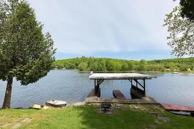a dock in the middle of a lake at Muskoka Cabana - Sandy beach cottage in Muskoka in Utterson