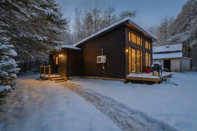 a log cabin in the snow with the lights on at 3-bedroom Villa in Lakefield #17 in Lakefield