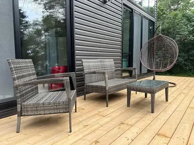 three wicker chairs and a table on a deck at 3-bedroom Villa in Lakefield #17 in Lakefield