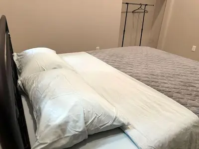 a bed with white sheets on it in a room at 3-bedroom Villa in Lakefield #17 in Lakefield