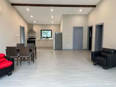 a living room with a table and chairs and a kitchen at 3-bedroom Villa in Lakefield #11 in Lakefield