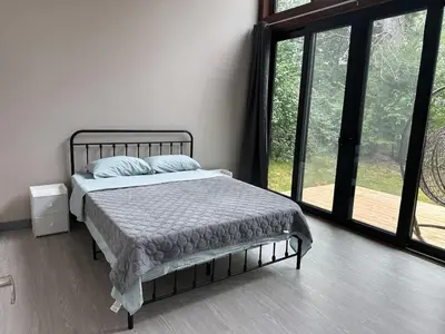a bedroom with a bed and a large window at 3-bedroom Lakefront Villa #10 in Lakefield