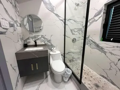 a bathroom with a toilet and a sink and a mirror at 3-bedroom Lakefront Villa #10 in Lakefield
