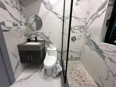 a bathroom with a shower and a toilet and a sink at 3-bedroom Lakefront Villa #10 in Lakefield