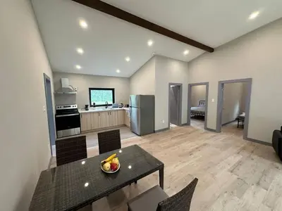 a living room with a table and a kitchen at 3-bedroom Lakefront Villa #2 in Lakefield