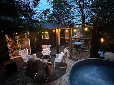 a deck with chairs and a swimming pool at night at The Muskoka Nest in Utterson