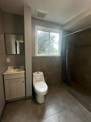 a bathroom with a toilet and a sink and a window at 5-bedroom Villa in East Gwillimbury in East Gwillimbury