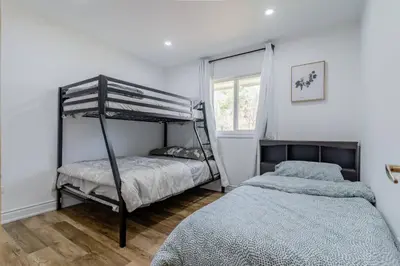 a bedroom with two bunk beds and a window at Private cottage with 26 acre & outdoor games in Bracebridge