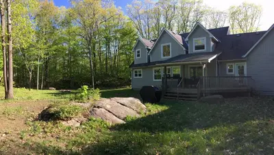 a house with a porch and a yard at Wares Muskoka Lakes Estate in Gravenhurst
