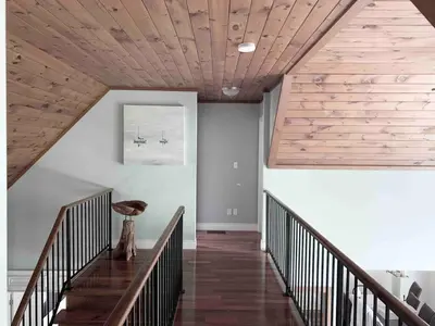 a hallway with a wooden ceiling and stairs at Wares Muskoka Lakes Estate in Gravenhurst