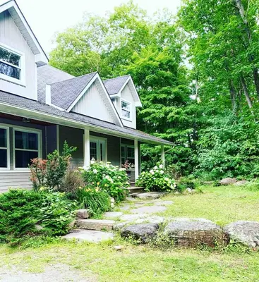 a house with a yard with rocks in front of it at Wares Muskoka Lakes Estate in Gravenhurst