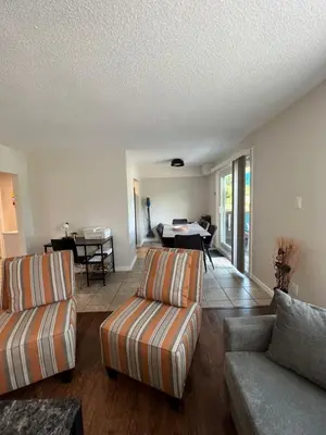 a living room with two couches and a table at Spacious Second Floor Garden View Apartment in Wasaga Beach