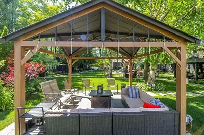 a pavilion with a table and chairs in a park at Spacious Second Floor Garden View Apartment in Wasaga Beach