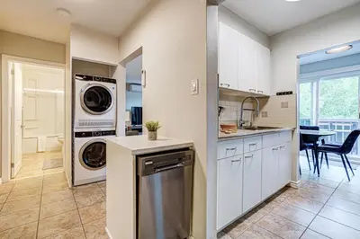 a kitchen with a washing machine and a washer and dryer at Spacious Second Floor Garden View Apartment in Wasaga Beach
