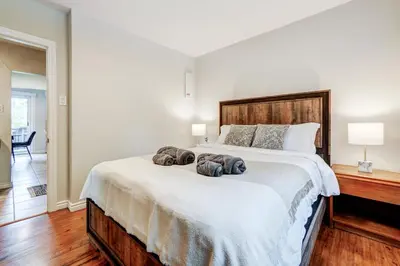 a bedroom with a large bed with two towels on it at Spacious Second Floor Garden View Apartment in Wasaga Beach