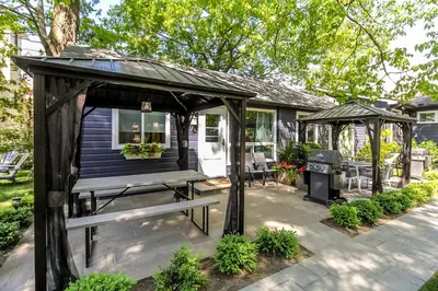 a porch with a picnic table and a gazebo at The Cozy Shore Cottage - Standard Attached in Wasaga Beach