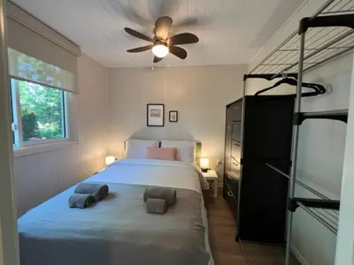 a bedroom with a bed and a ceiling fan at The Cozy Shore Cottage - Standard Single in Wasaga Beach