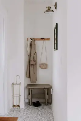 a hallway with a bench and a coat hanging on a wall at The Wild Rose - Cozy PEC Rental in Picton in Picton