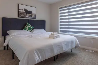 a bedroom with a large bed and a window at 4Bed25 BathBrand newNiagara FallsSleeps12 in Thorold
