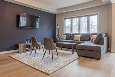 a living room with a couch and a table and chairs at 4Bed25 BathBrand newNiagara FallsSleeps12 in Thorold