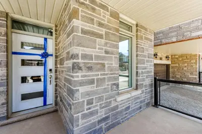 a brick wall with a blue door and window at Brand New 7beds-kingbedsfamilysleep15playtable in Milton