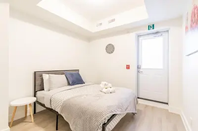 a bedroom with a bed with a teddy bear on it at Westend Suites - Stylish 3BR Condo near High Park Trails in Toronto