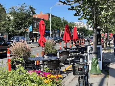 a group of tables and chairs with red umbrellas at Westend Suites - Modern 1BR Apartment - 8min walk to High Park in Toronto