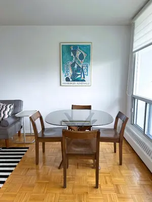 a dining room with a glass table and chairs at The Charming Downtown Stop in Toronto
