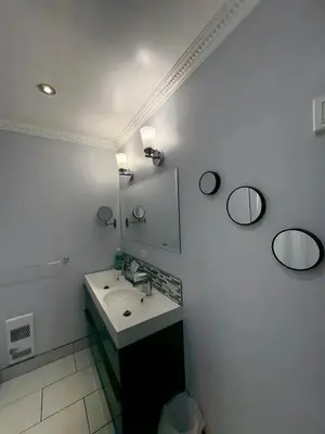 a bathroom with a sink and two mirrors at Chapman H in Toronto