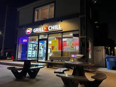 a restaurant with benches in front of it at night at Three Bedroom Spacious Bangalow with Free Parking, closer to commercial area and highways in Mississauga