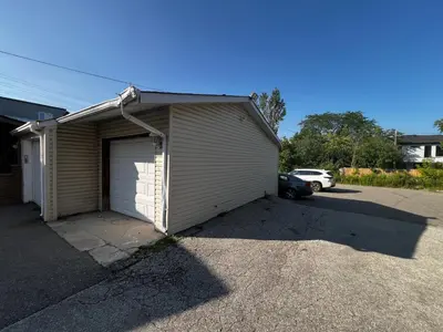a garage with a car parked in a parking lot at Three Bedroom Spacious Bangalow with Free Parking, closer to commercial area and highways in Mississauga