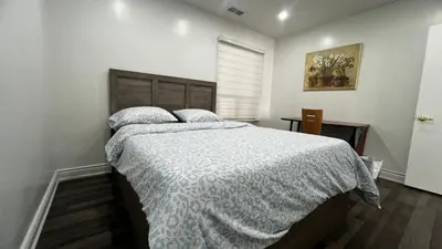 a bedroom with a bed with a white comforter at Three Bedroom Spacious Bangalow with Free Parking, closer to commercial area and highways in Mississauga