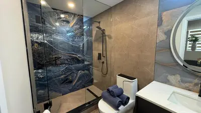 a bathroom with a shower and a toilet and a sink at Luxury 2-Bedroom Designer Suite Richmond Hill Lake Wilcox in Richmond Hill