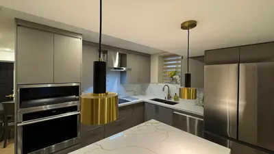 a kitchen with stainless steel appliances and yellow lights at Luxury 2-Bedroom Designer Suite Richmond Hill Lake Wilcox in Richmond Hill