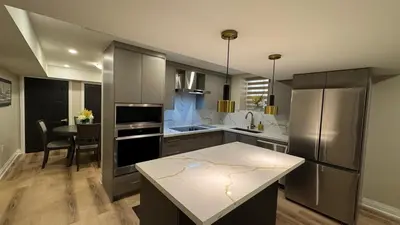 a kitchen with stainless steel appliances and a table at Luxury 2-Bedroom Designer Suite Richmond Hill Lake Wilcox in Richmond Hill