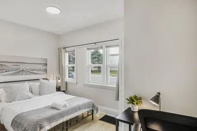 a white bedroom with a bed and a window at Chic 2 BR Urban Retreat Near Beach Free Parking in Oshawa