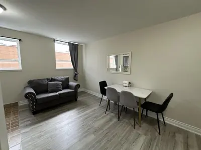 a living room with a couch and a table and chairs at Furnished Simcoe Lofts in Oshawa