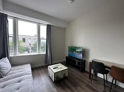 a living room with a couch and a tv at Furnished Simcoe Lofts in Oshawa