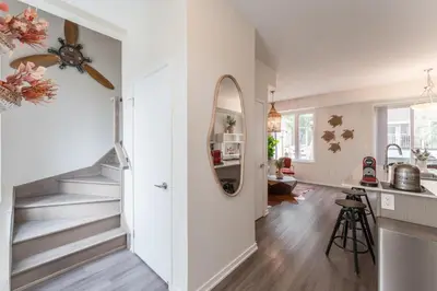 a staircase in a living room with a mirror at Luxury Townhouse in Vaughan in Vaughan